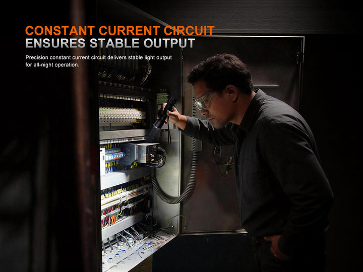 Person working on electrical equipment using a Fenix C7 Pro Quick-Charging Work Flashlight with text about constant current circuit