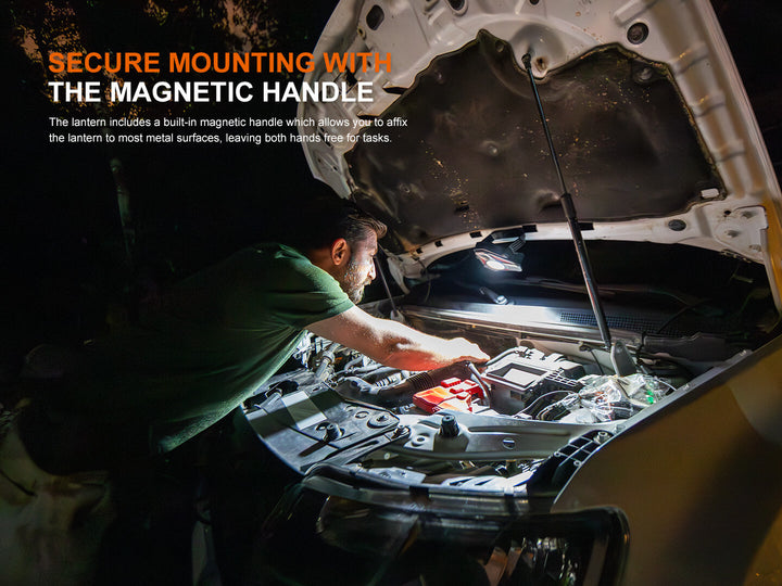 Person working under a car using the Fenix CP50R Road Hazard Camping Lantern's magnetic handle attached