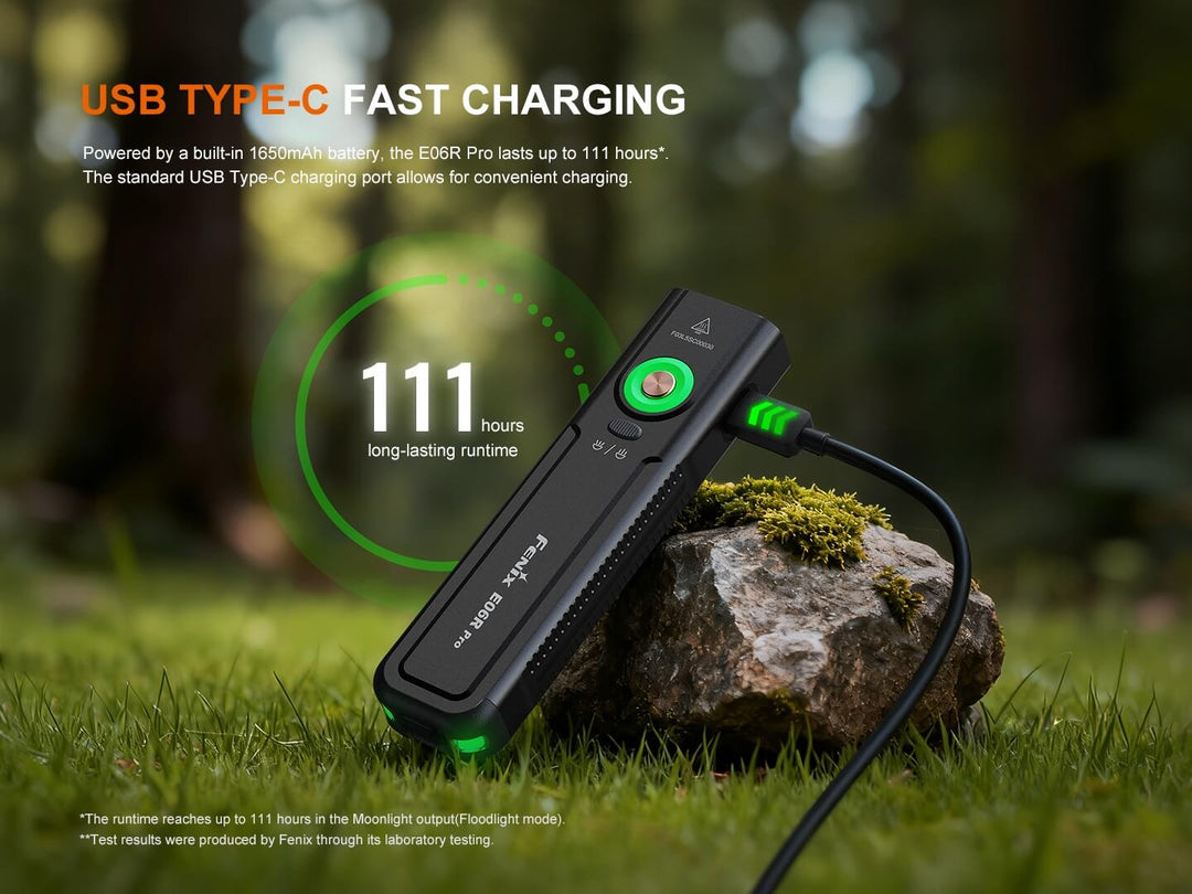 USB Type-C fast charging Fenix E06R Flashlight on a rock with grass and blurred natural background