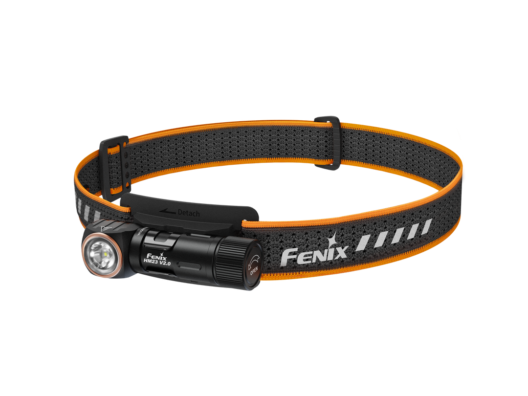 A black Fenix HM23 V2.0 lightweight detachable headlamp with an orange adjustment strap.