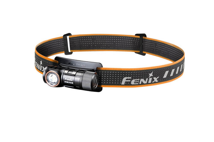 A black Fenix HM50R V2.0 LED headlamp with an orange adjustment strap and white LED light.