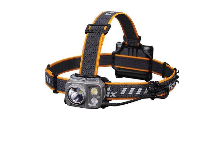 A Fenix HP16R Rechargeable Headlamp with a black and orange adjustable strap and a gray light source module.