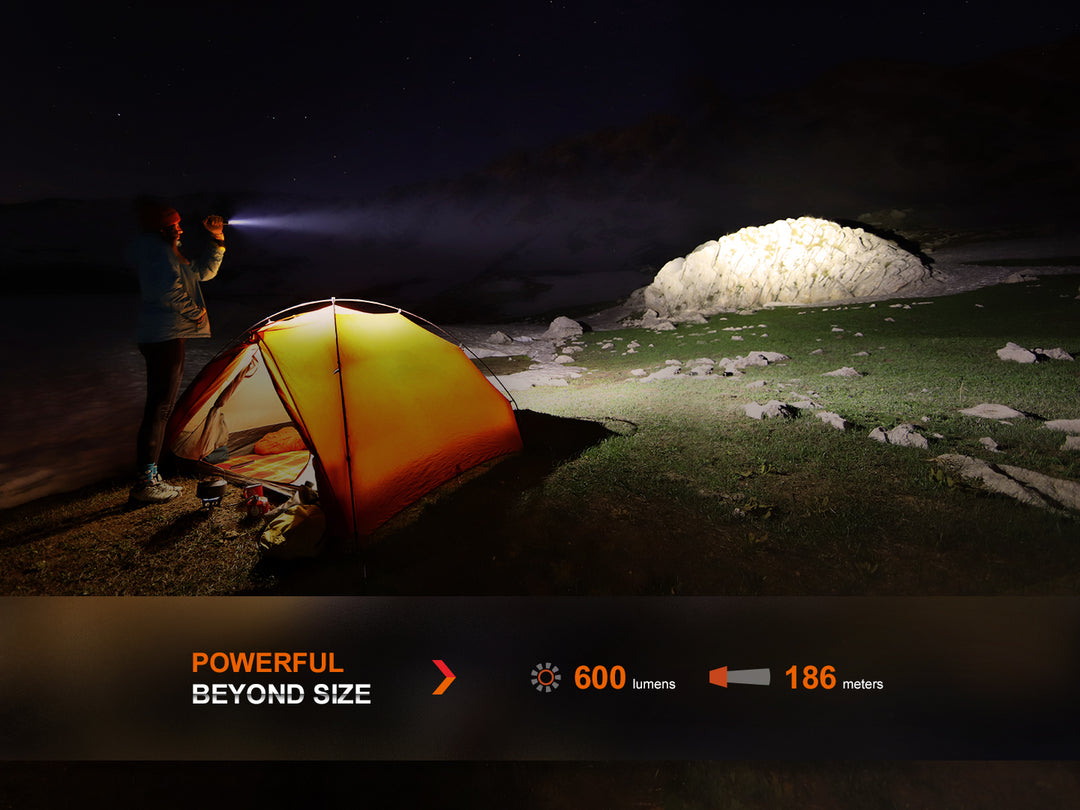 Fenix LD12R dual light flashlight used to light up a large stone outside of a tent