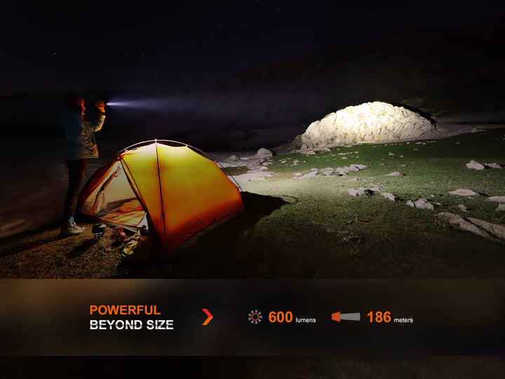Fenix LD12R dual light flashlight used to light up a large stone outside of a tent