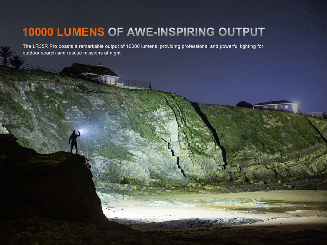Person with a Fenix LR35R Pro Searchlight on a cliffside at night, illuminating the area with 10000 lumens of light.