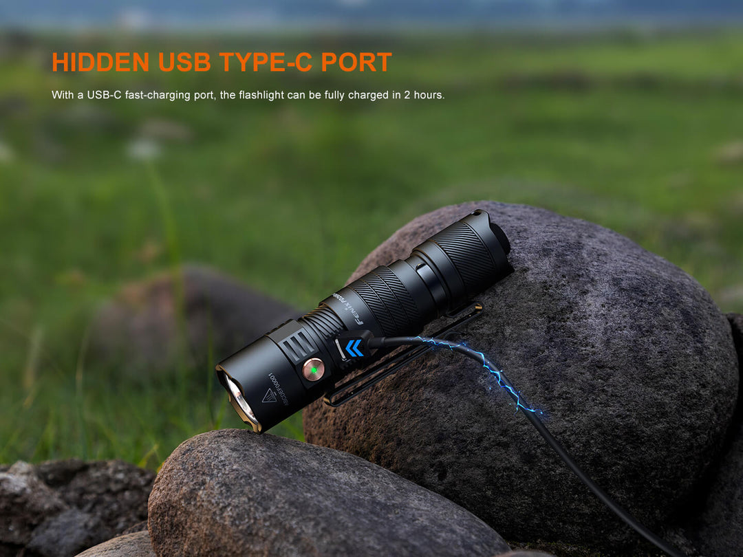 Fenix PD26R ACE Customizable Compact Flashlight with USB-C charging cable on a rock in a natural setting