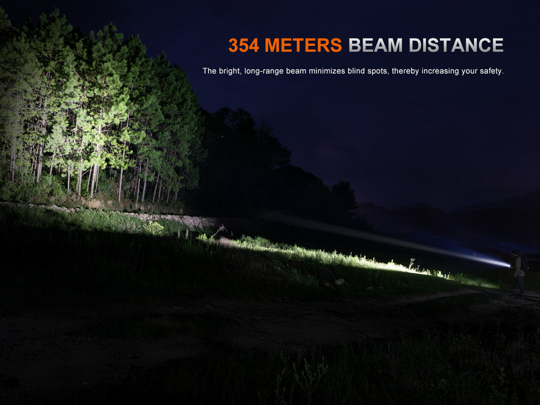 Fenix PD26R ACE Customizable Compact Flashlight beam illuminating a forest at night with text indicating beam distance.
