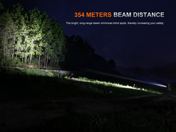 Fenix PD26R ACE Customizable Compact Flashlight beam illuminating a forest at night with text indicating beam distance.