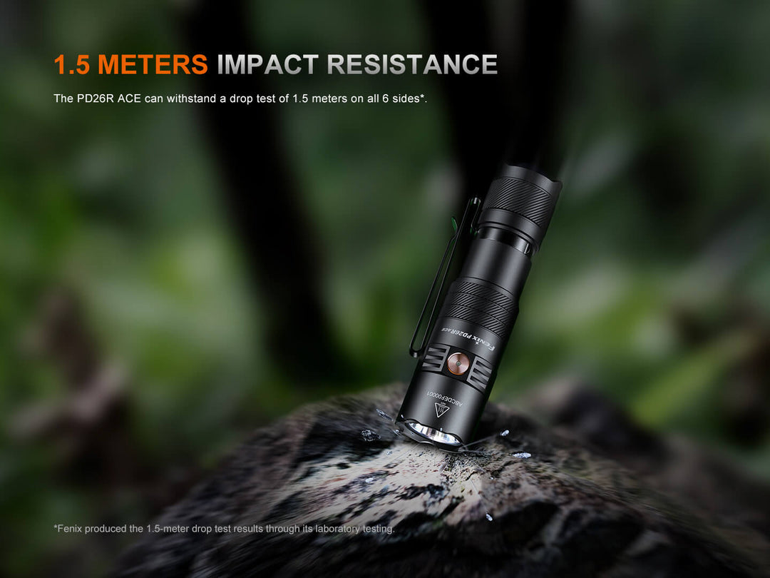 Black Fenix PD26R ACE Customizable Compact Flashlight on a rock with '1.5 Meters Impact Resistance' text