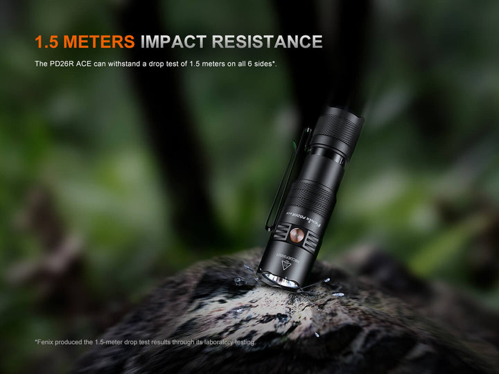 Black Fenix PD26R ACE Customizable Compact Flashlight on a rock with '1.5 Meters Impact Resistance' text