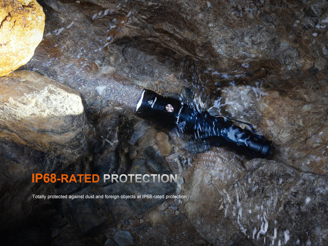 Black waterproof Fenix PD36R ACE flashlight on rocks with 'IP68-RATED PROTECTION' text