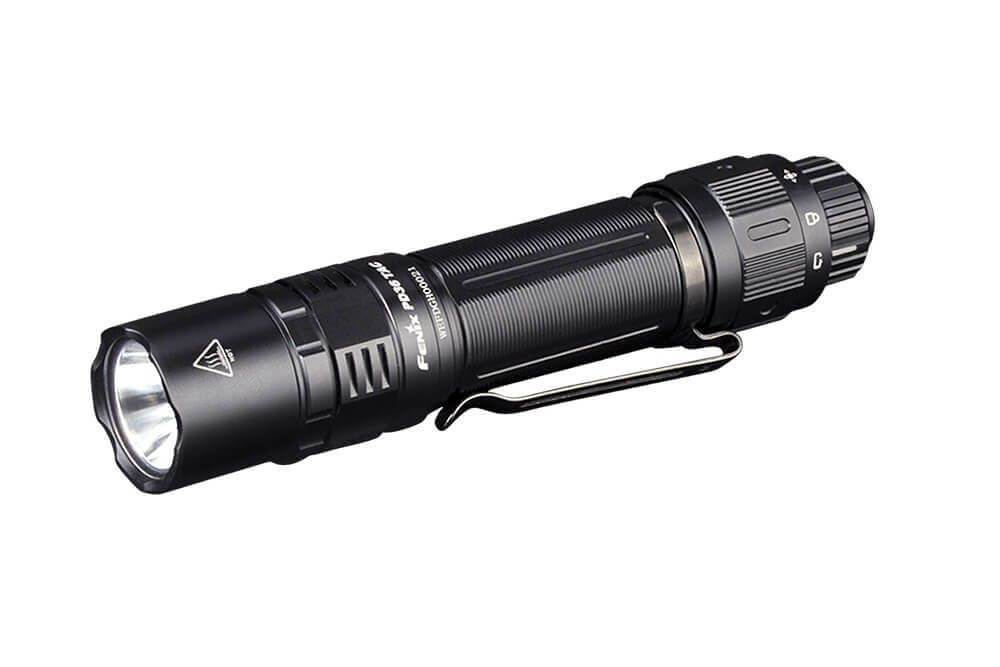 A black Fenix PD36 TAC tactical flashlight with a pocket-clip and a beam of light extending outward.