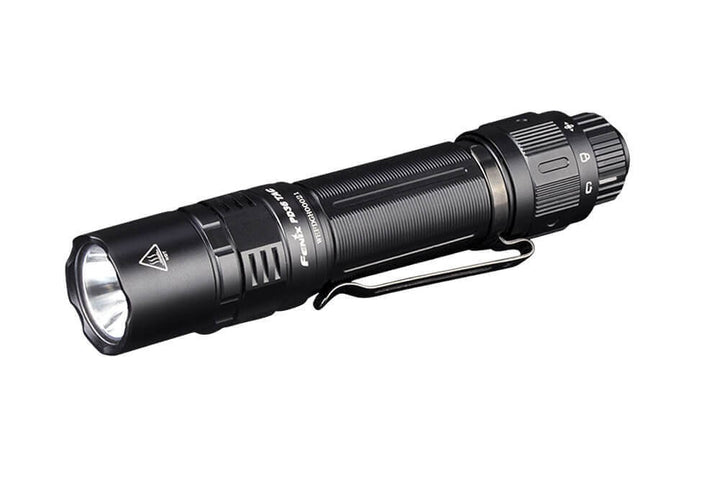 A black Fenix PD36 TAC tactical flashlight with a pocket-clip and a beam of light extending outward.
