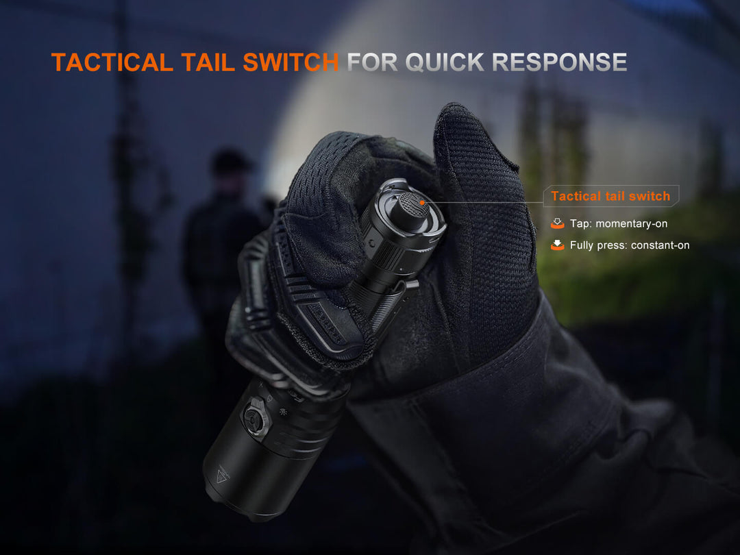 The tactical tail switch of the Fenix TK15R adaptive flashlight on a gloved hand with a dark background