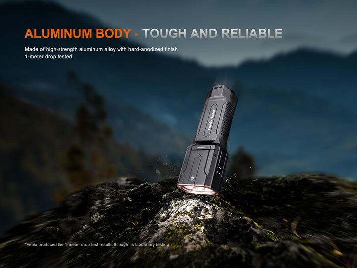 Tough and reliable Fenix TK28R Flashlight on a rocky surface with mountain background
