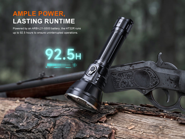 Fenix HT32R resting against a rifle on a log, up to 92.5 hours of runtime on the ARB-L21-5500 battery