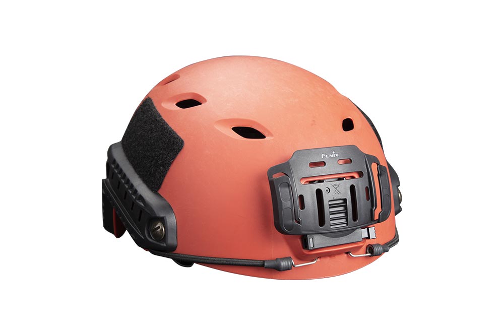 A Fenix ALG-04 Helmet Clip attached to an orange helmet, designed for easy attachment and detachment of a headlamp to the helmet.