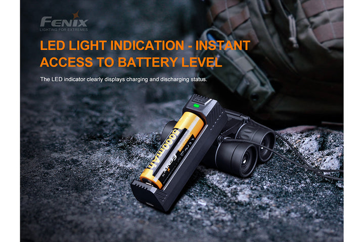 Fenix ARE-X1 V2 battery charger on stone with battery level indicator lit up