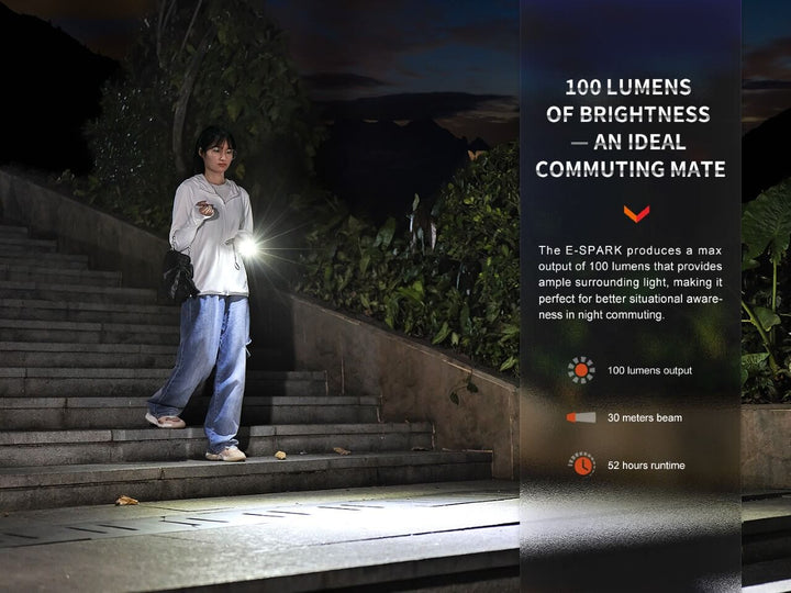 A person walking down steps, using the Fenix E-SPARK thin powerbank flashlight to light their way