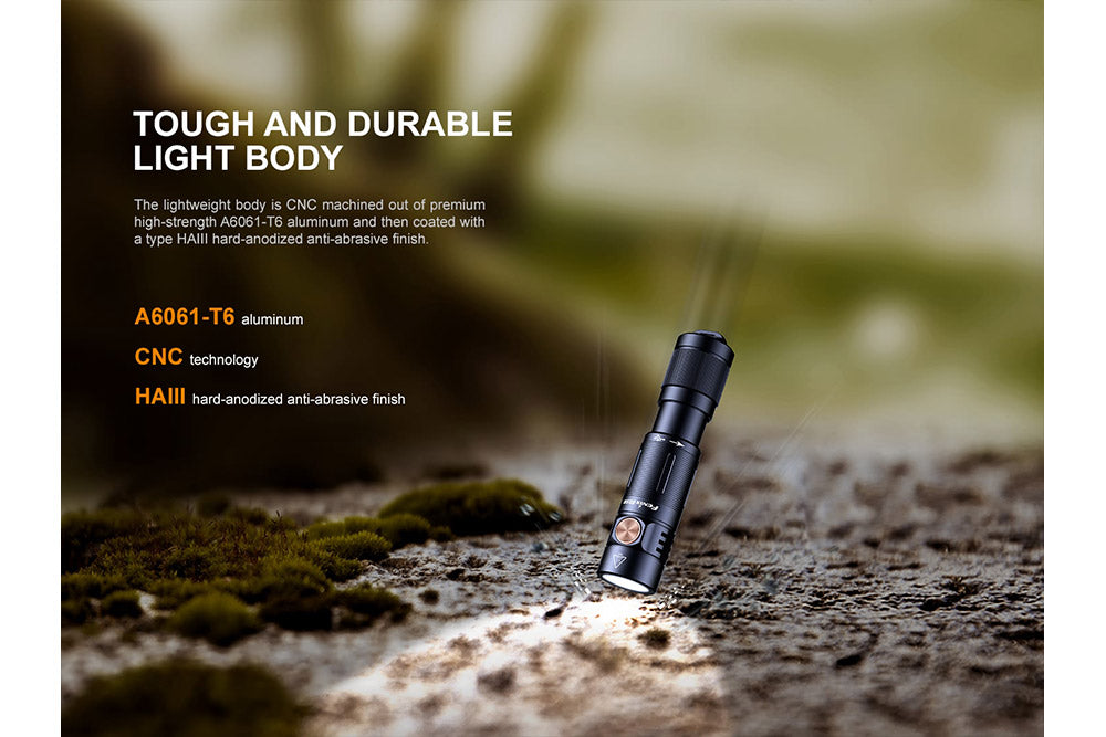 Fenix E05R Mini Keychain LED Flashlight dropped onto stone