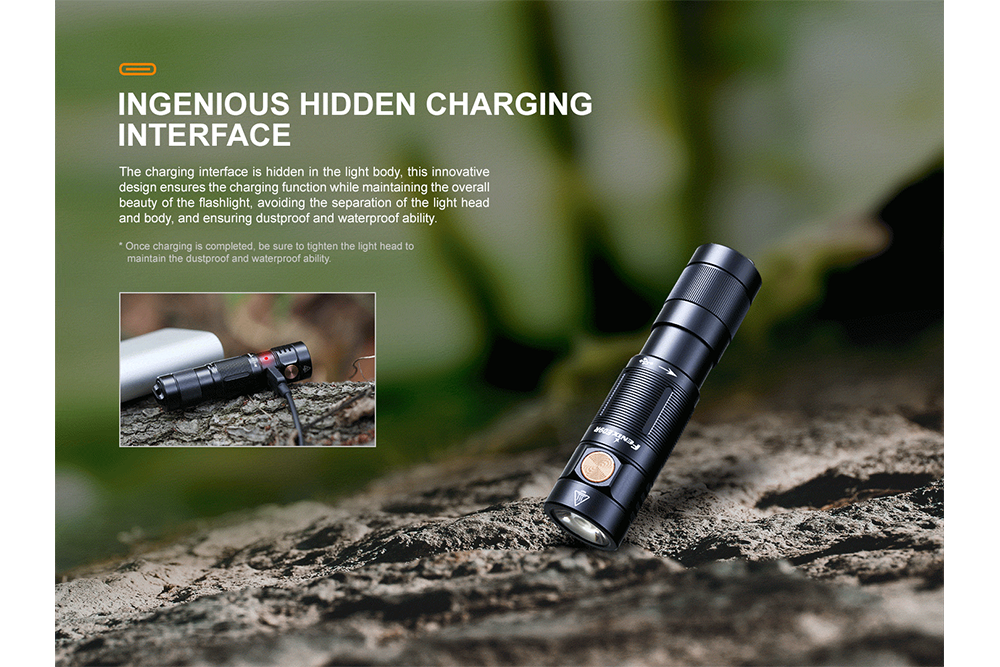 Fenix E09R rechargeable flashlight plugged in via hidden charging port, lying on a log in the woods