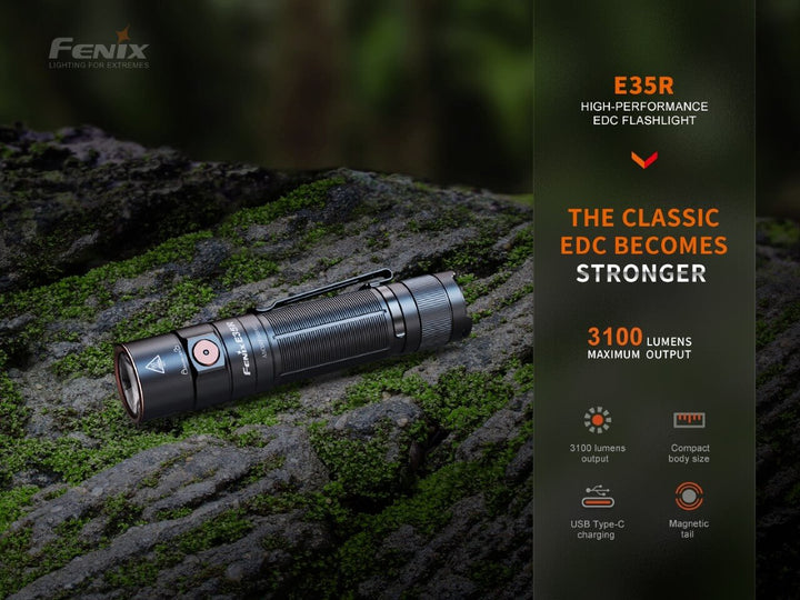 Fenix E35R high-performance rechargeable LED flashlight sitting on mossy stone