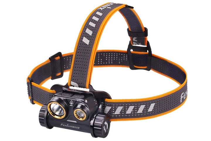 A black Fenix HM65R rechargeable LED headlamp with an orange and black adjustable headband, featuring two LED lights on the front.