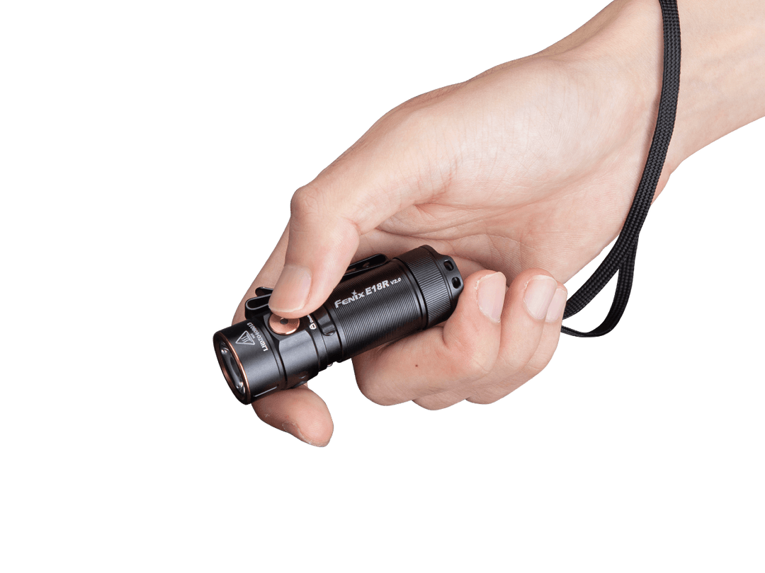 Fenix e18r v2 rechargeable flashlight held in hand with a lanyard around the wrist